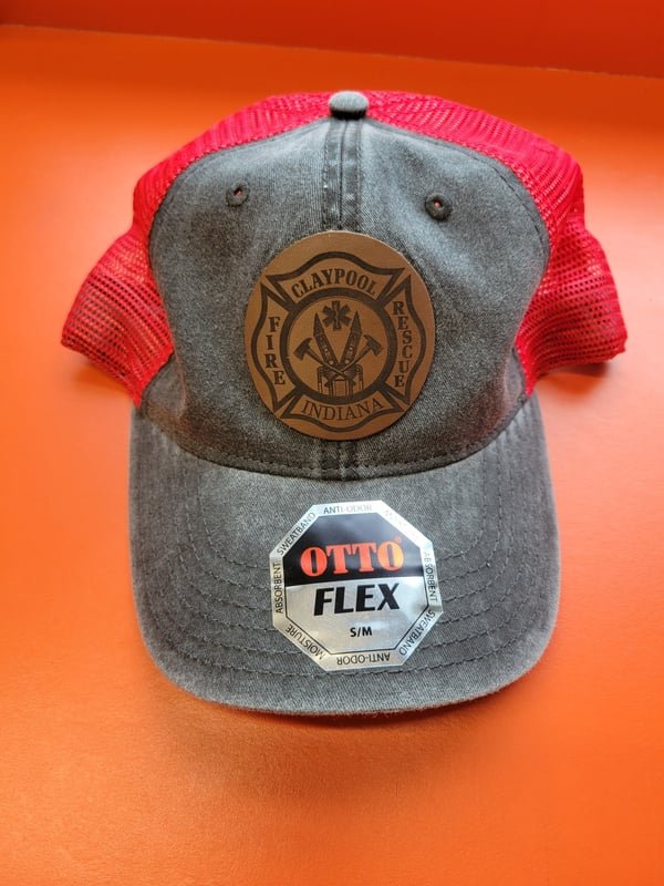 A grey and red trucker cap with a leather patch engraved with the Claypool Fire Rescue Indiana maltese-cross crest.