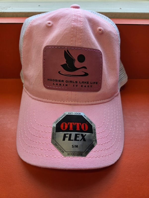 A pink cap with a leather patch engraved with the Hoosier Girls Lake Life bird logo.
