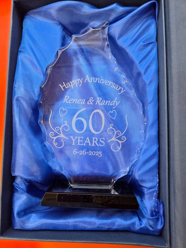 A glass award in a blue presentation box engraved Happy Anniversary, Renea and Randy, 60 Years.