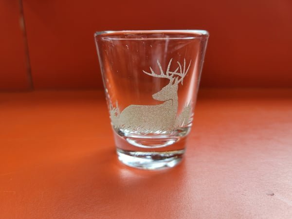 A heavy rocks glass etched with a resting deer.