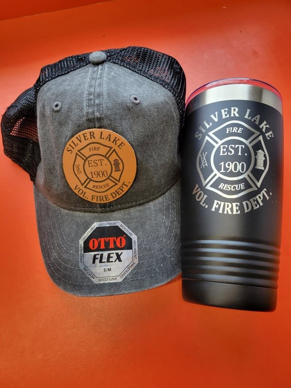 A grey cap and a black tumbler, both carrying the Silver Lake Volunteer Fire Department Est. 1900 crest.