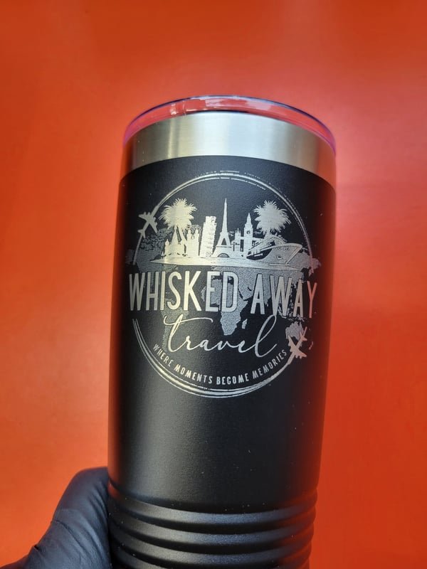 A black tumbler engraved with the Whisked Away Travel skyline and palm logo.