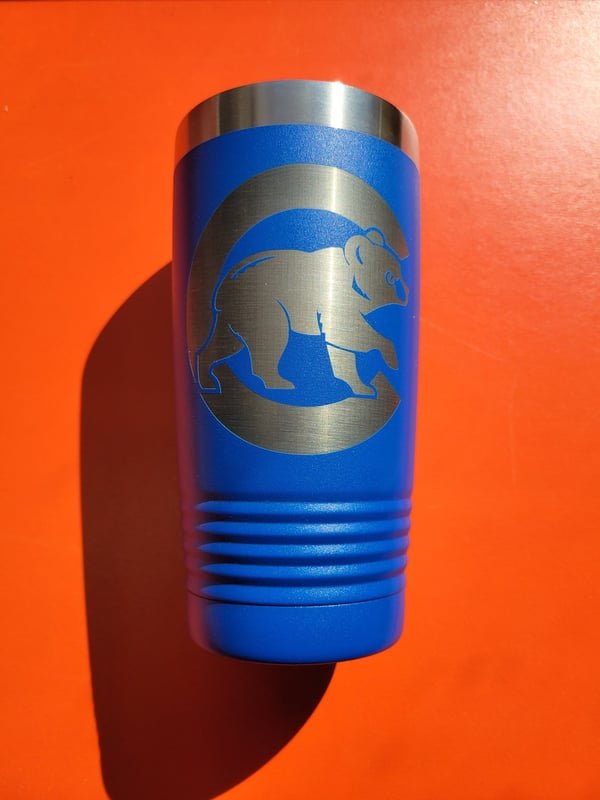A blue tumbler engraved with a walking bear silhouette.