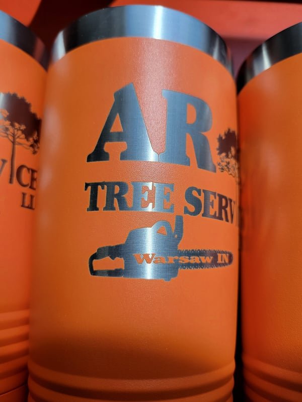 A tan tumbler engraved with the AR Tree Services logo and Warsaw, IN in colour-shifted marks.