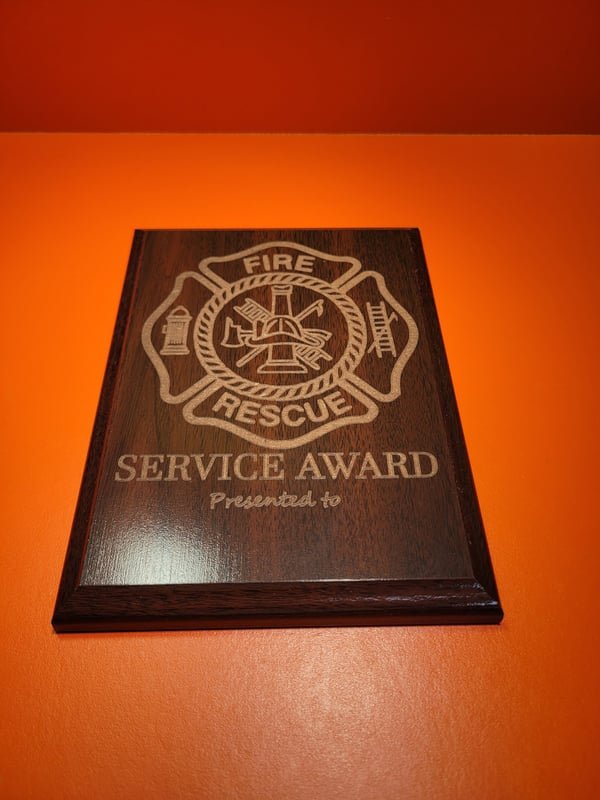 A wood plaque engraved with a fire rescue maltese cross above the words Service Award.