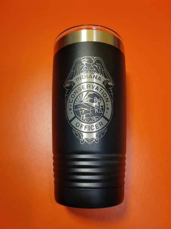A black tumbler engraved with the Indiana Conservation Officer badge.