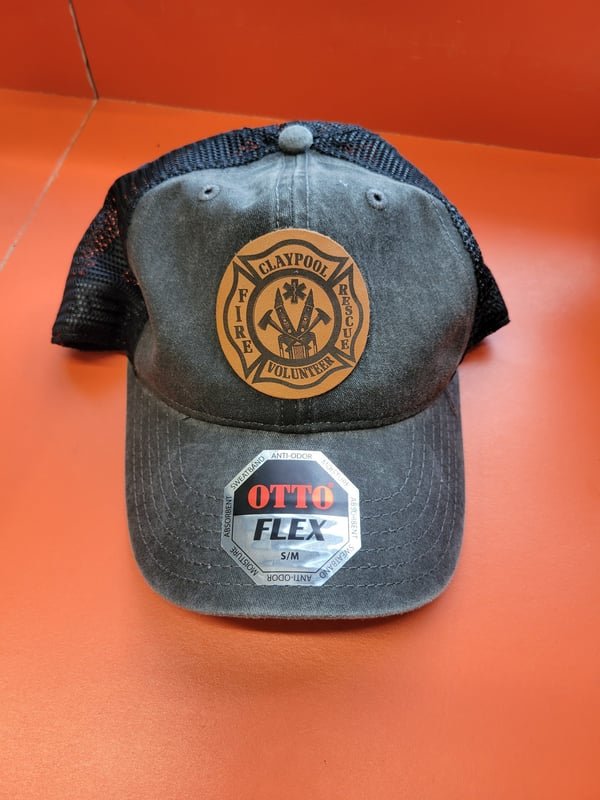 A grey trucker cap with a leather patch engraved with the Claypool Volunteer fire crest.