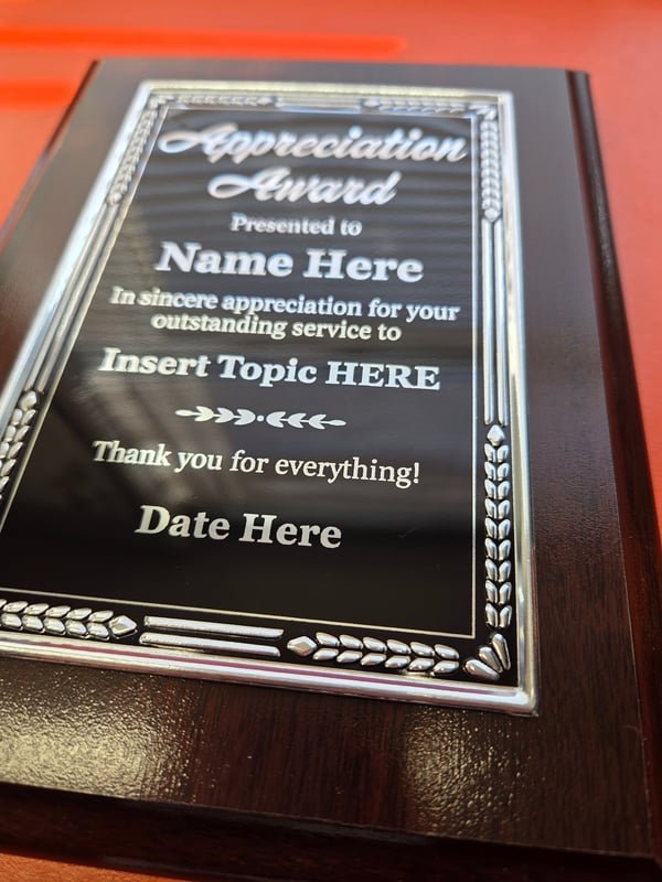 A black and silver plaque with a decorative border, engraved as an Appreciation Award template.