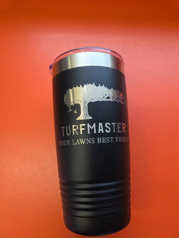 A black tumbler engraved with the TurfMaster tree logo and the words Your Lawns Best Friend.