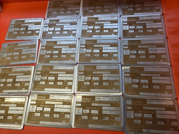 Rows of engraved brass name plates laid out ready for mounting.