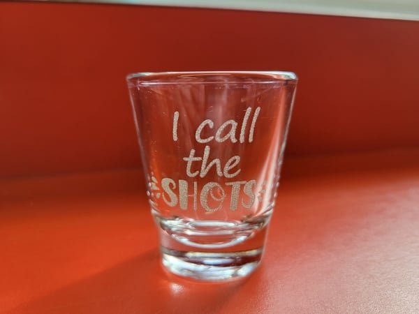 A shot glass etched with the words I call the shots.