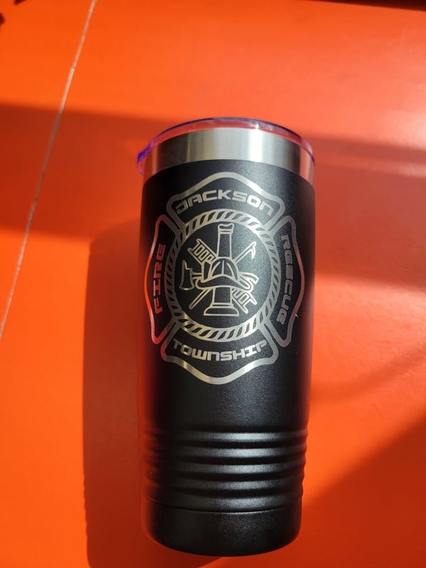 A black tumbler engraved with the Jackson Township Fire Rescue crest.