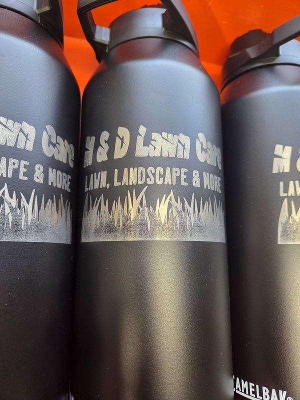 Black insulated bottles engraved with the H&D Lawn Care logo and a grass silhouette.