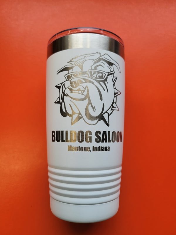 A white tumbler engraved with a bulldog mascot reading Bulldog Saloon, Mentone, Indiana.
