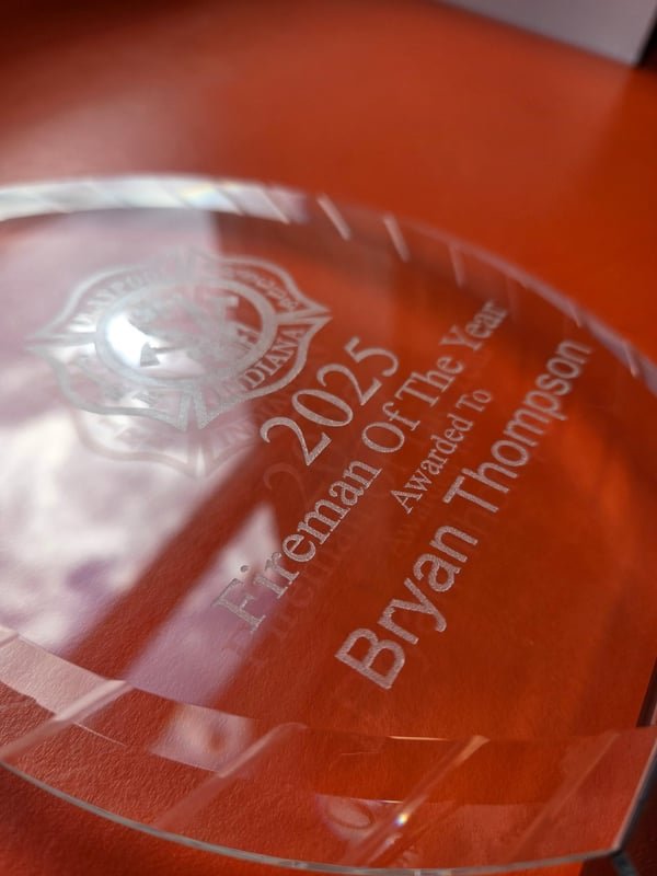 A clear acrylic award engraved 2025 Fireman Of The Year, awarded to Bryan Thompson.