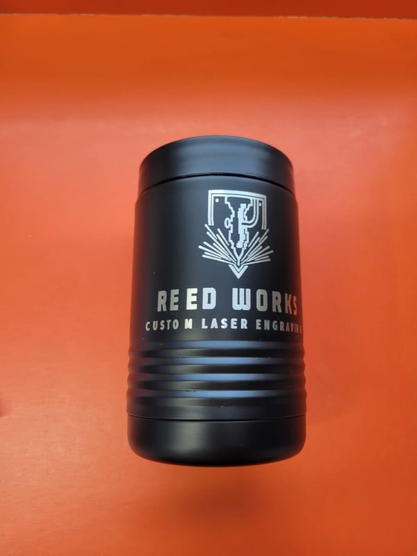 A black tumbler engraved with the Reed Works Custom Laser Engraving logo.
