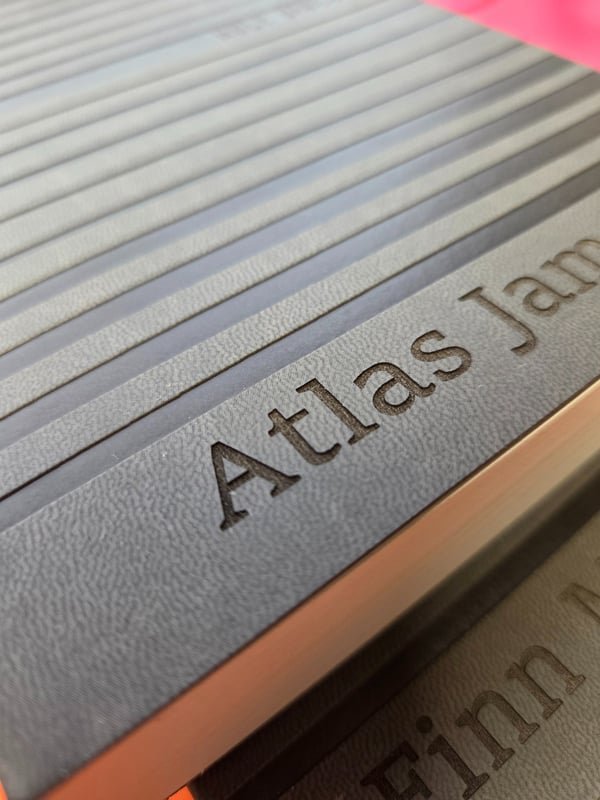An aluminium rail fiber-engraved with large clear lettering.