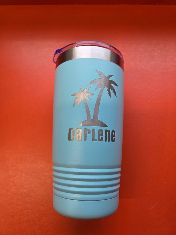 A pale blue tumbler engraved with palm trees and the name Darlene.