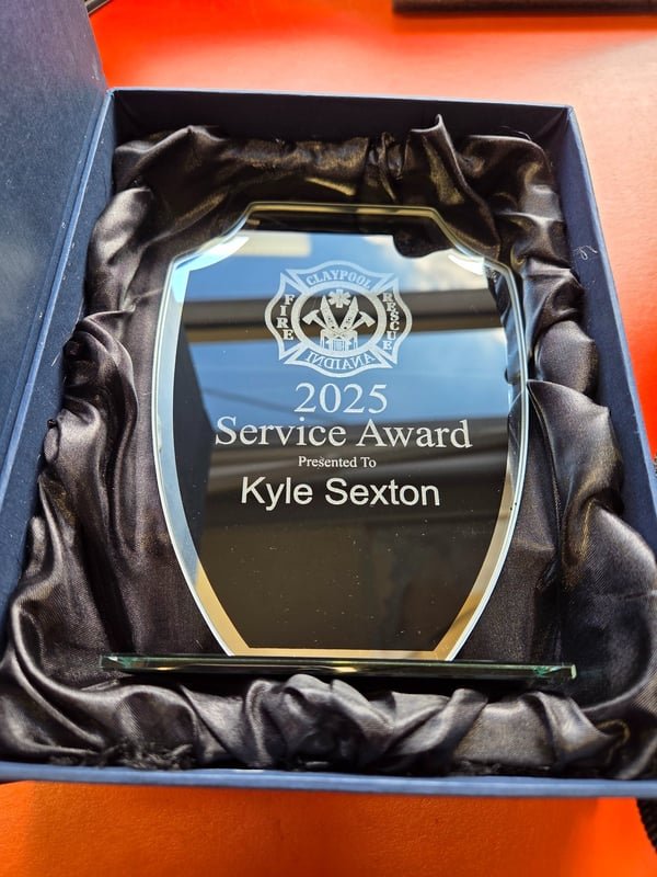 A mirrored acrylic award in a satin-lined box, engraved 2025 Service Award presented to Kyle Sexton.