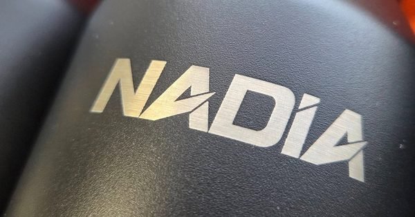 A close-up of a dark bottle engraved with the name Nadia in bold gold-toned marks.