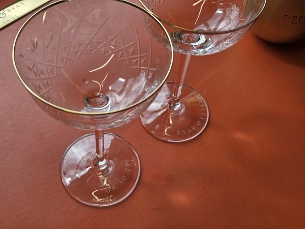 Two cut-crystal wine glasses etched near the base with a couple's names and their wedding date.