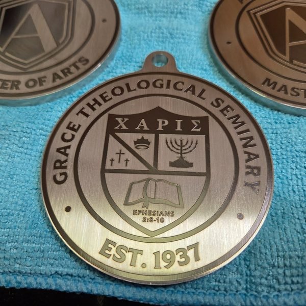A stainless medallion fiber-engraved with the Grace Theological Seminary shield and motto.