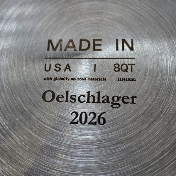 The base of a stainless pan fiber-engraved Made in USA, 8QT, Oelschlager 2026.