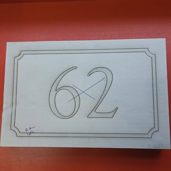 The hand-marked paper template used to lay out a cut stone address plaque.