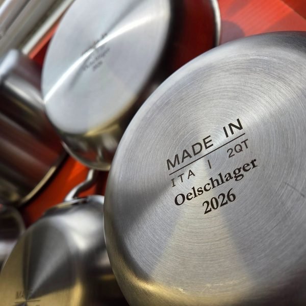 Stacked stainless pans with their fiber-engraved bases turned to the camera.