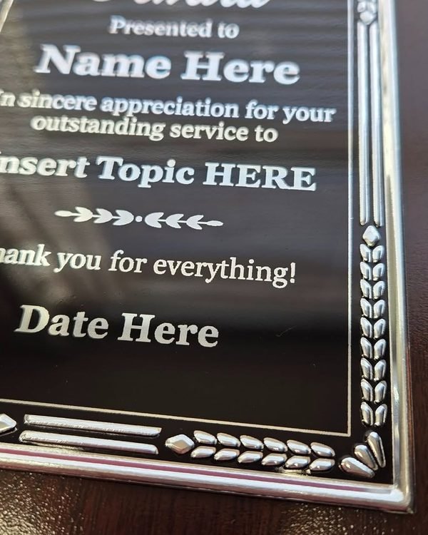 A close-up of an Appreciation Award plaque, the engraved template wording running across the black plate.