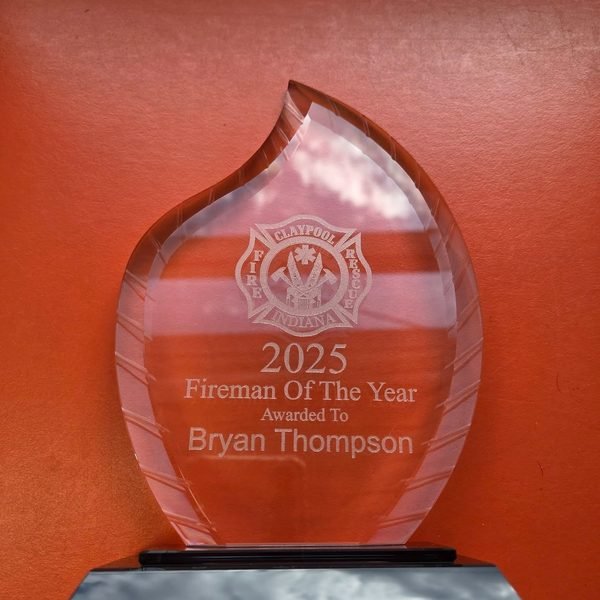 A flame-shaped acrylic award engraved with the Claypool Fire Rescue crest and the words 2025 Fireman Of The Year, Bryan Thompson.