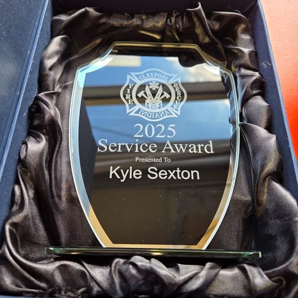 A mirrored acrylic award in a satin-lined box, engraved 2025 Service Award presented to Kyle Sexton.