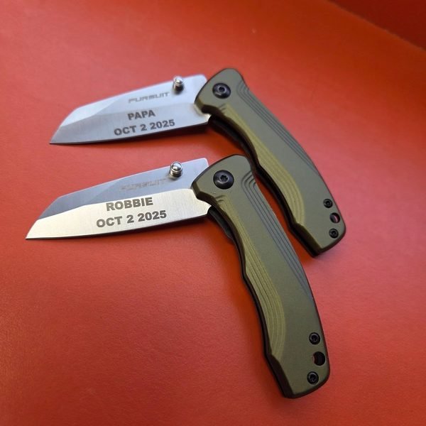 Two Pursuit folding knives with green handles, their blades fiber-engraved PAPA and ROBBIE, Oct 2 2025.