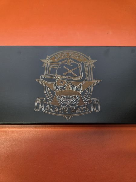 A black decanter stand engraved with the A Co 293rd Black Hats crest, a skull in a cavalry hat above crossed rifles.