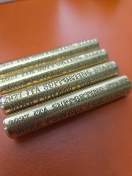 Four solid brass rods engraved 2027 ITA Supporting Staff, Mike Powell President in bold serif capitals.
