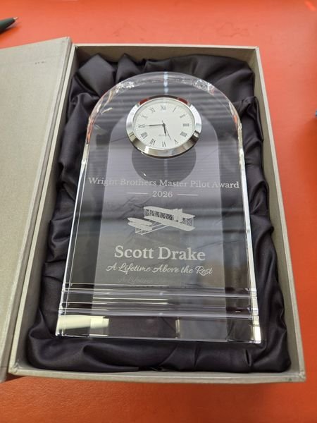 A domed crystal clock award in its satin-lined box, engraved Wright Brothers Master Pilot Award 2026 with a biplane above the name Scott Drake.