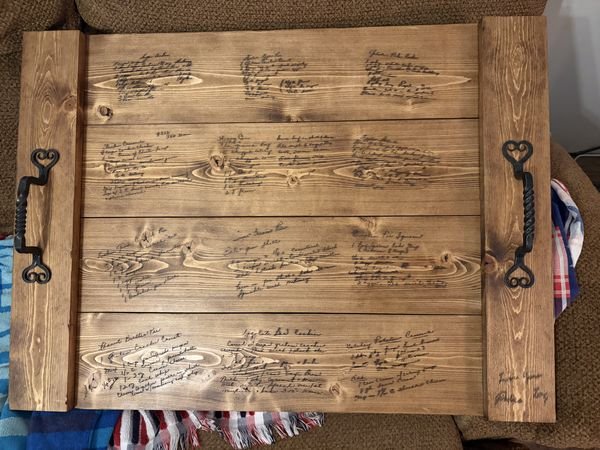 A stained pine serving tray with heart-scroll iron handles, its boards engraved with a dozen handwritten family recipes, Peanut Butter Pie among them.