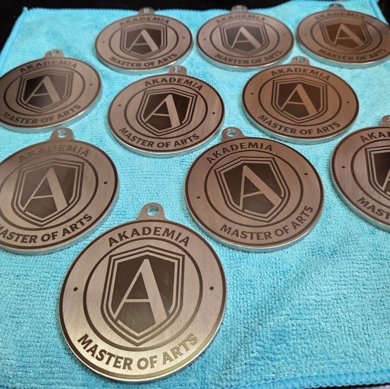 Ten identical medallions engraved AKADEMIA · MASTER OF ARTS around a shield bearing a capital A.
